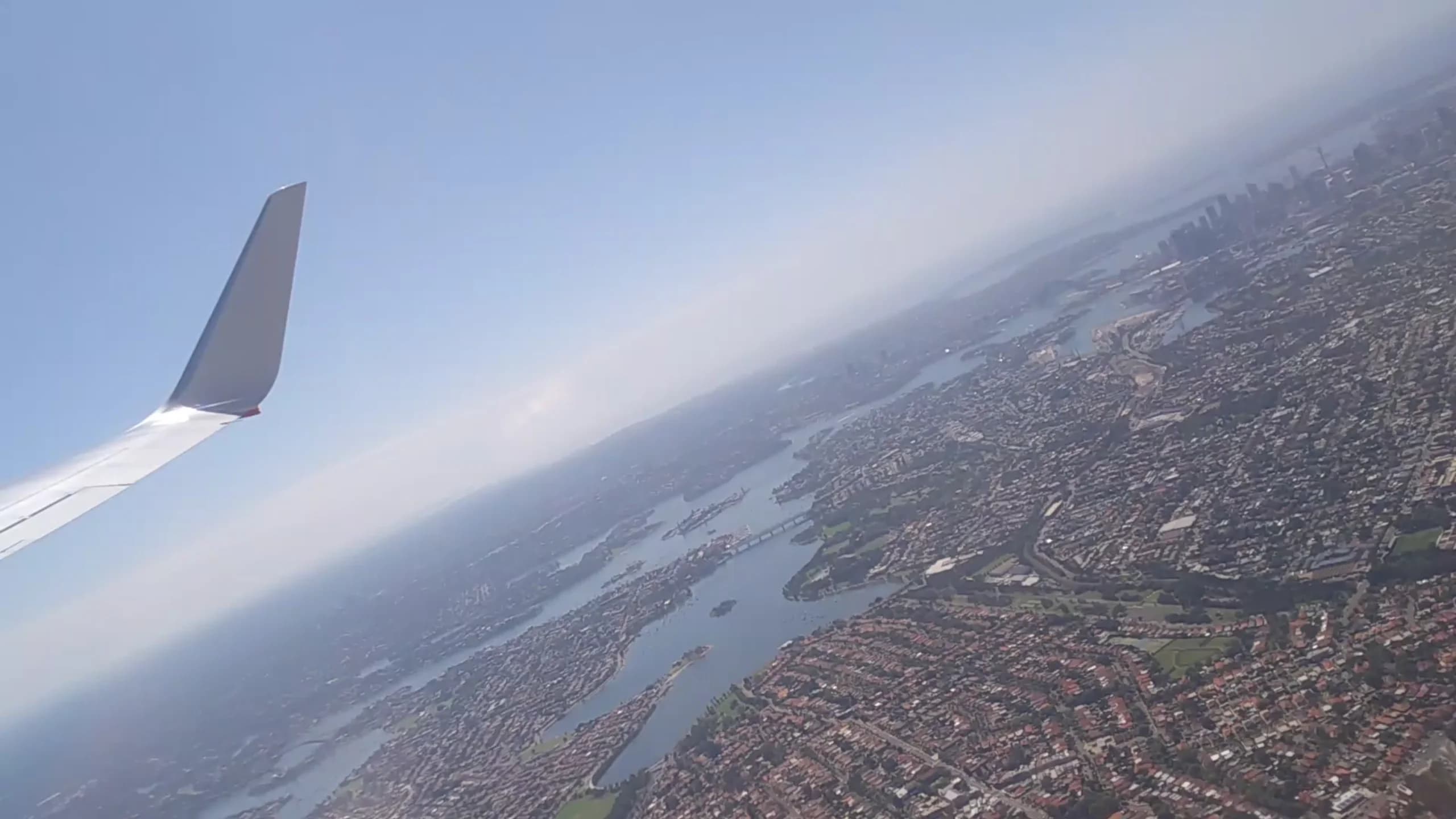 从 Sydney 住宅区望向城市天际线的航拍图,用于反映长期住房可负担性及不同世代的置业机会