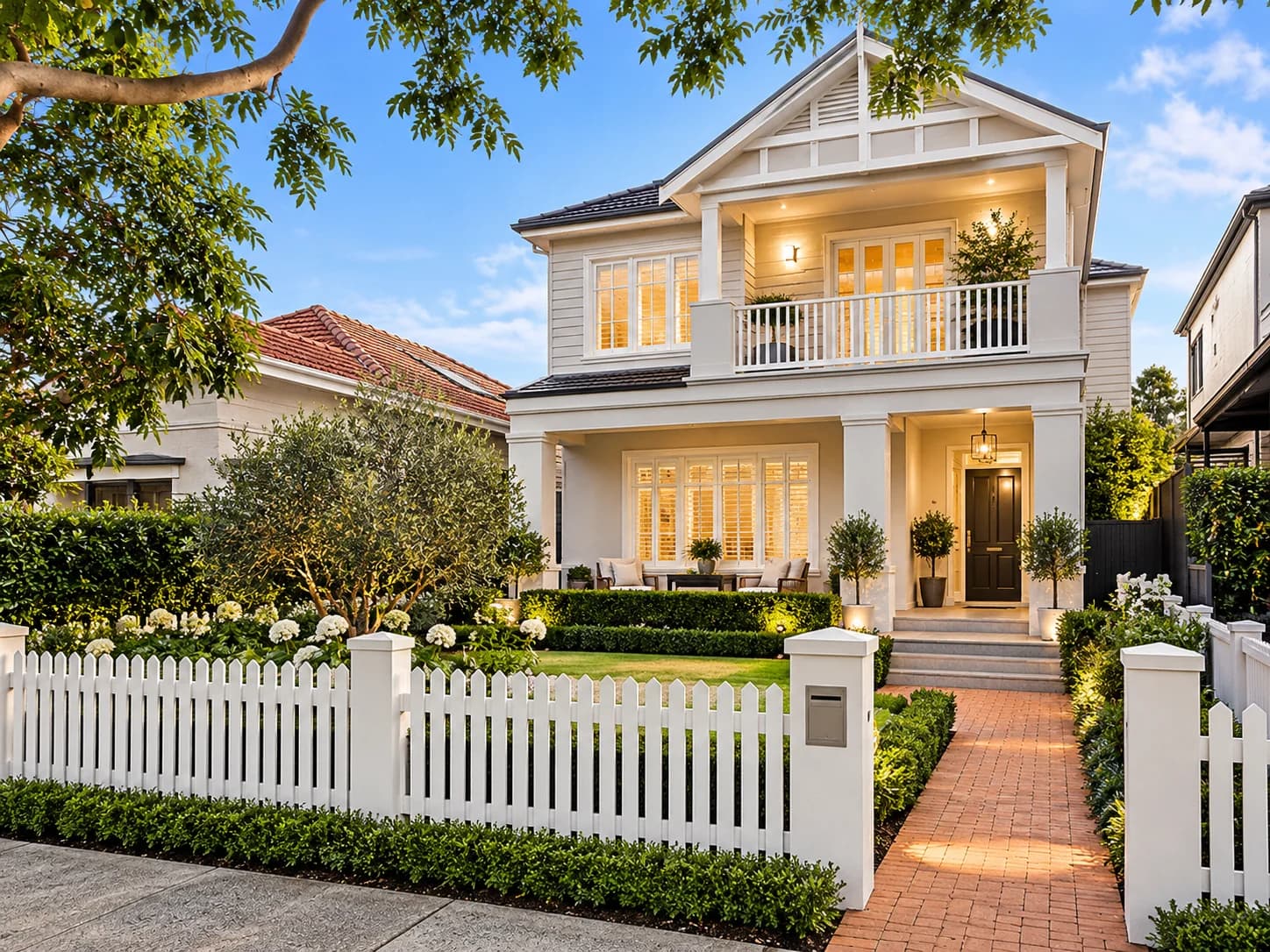 Two-storey weatherboard house with a fenced front garden