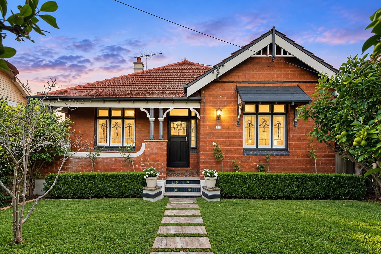 Brick bungalow with a front garden at dusk
